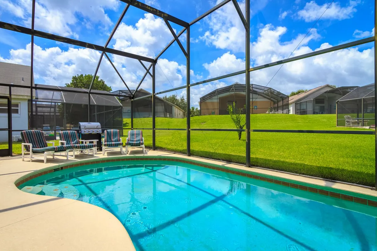 Screened pool enclosure and pool deck at a Florida home